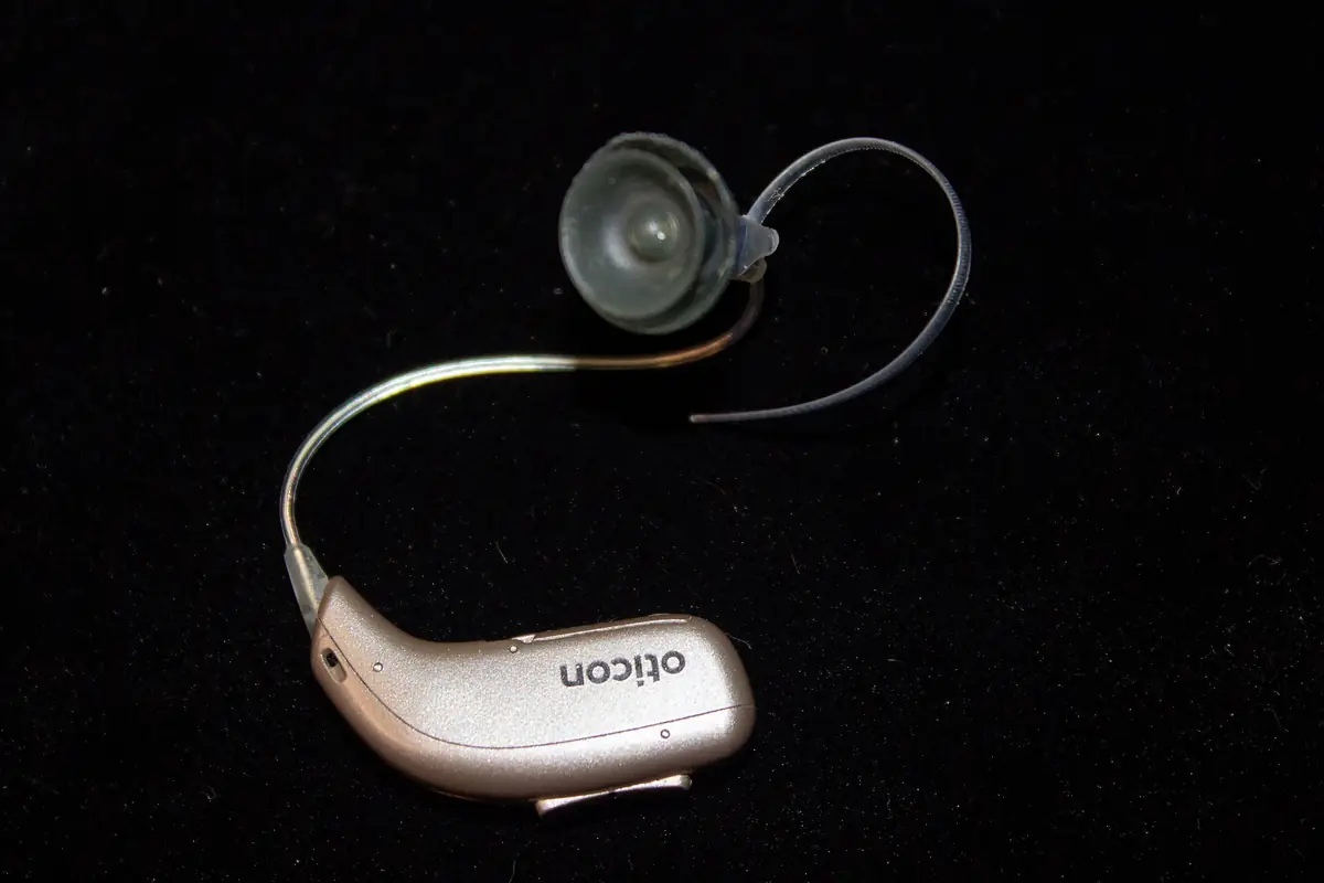 Close-up top view of a modern behind-the-ear hearing aid