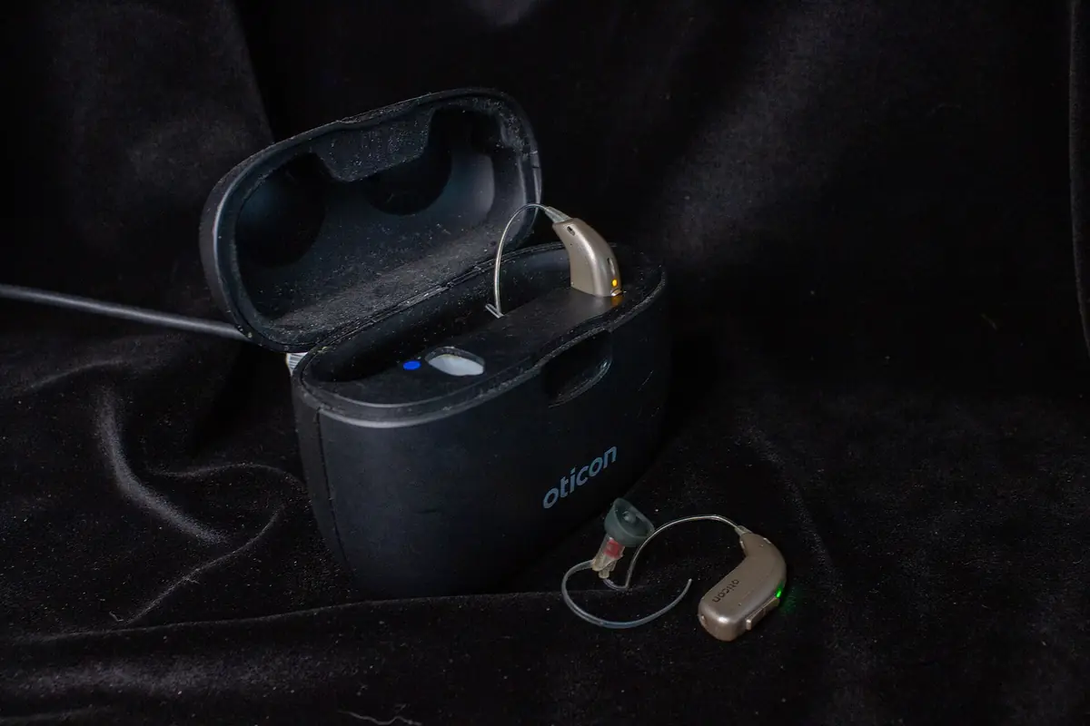 Rechargeable hearing aids resting in their charging case