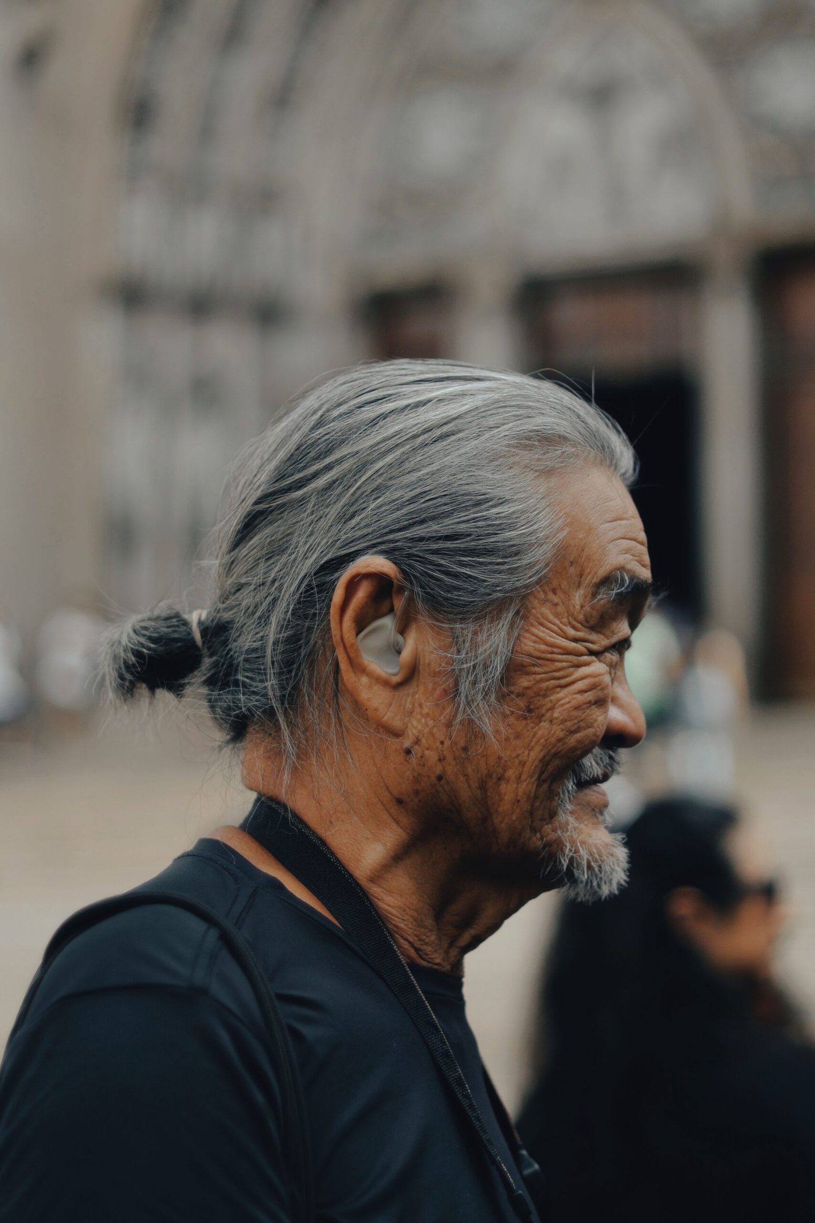 Elderly man wearing hearing aid outdoors